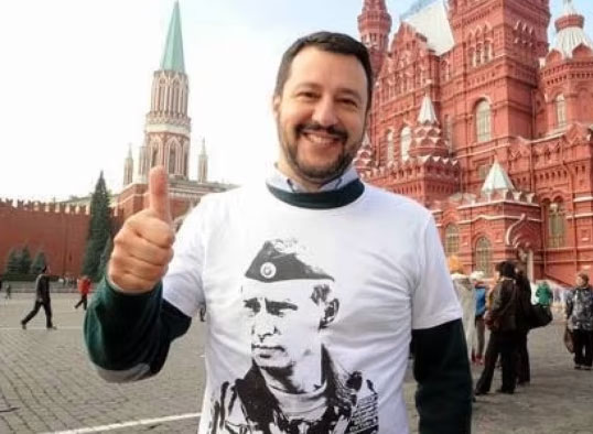 Picture of Salvini at the Kremlin wearing a t-shirt with Putin's face on it. He's giving a thumbs up